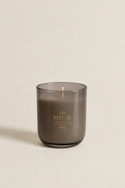 RITUAL scented candle in smoky-grey glass with gold lettering and transparent label by Aija Candle Studio